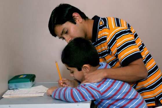 Indian boy with learning challenges being helped by his father